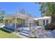 Beautiful home with a covered patio and a staircase, surrounded by landscaping and serene surroundings at 763 Siesta Dr, Sarasota, FL 34242