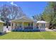 Inviting home features a well-maintained lawn, metal roof, and a charming porch at 763 Siesta Dr, Sarasota, FL 34242