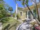 Beautiful yard featuring a well-manicured lawn, mature palm trees, and a charming walkway to the entrance at 763 Siesta Dr, Sarasota, FL 34242
