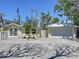 Quaint yellow home and garage with brick-paved driveway, bicycle, and white picket fence at 763 Siesta Dr, Sarasota, FL 34242