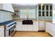 Bright kitchen with modern appliances, white cabinets, butcher block countertops, and patterned tile backsplash at 763 Siesta Dr, Sarasota, FL 34242