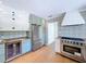 A kitchen with stainless steel appliances, white and light green cabinets and tile backsplash at 763 Siesta Dr, Sarasota, FL 34242