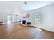 Sunlit living room with hardwood floors, fireplace, and french doors to outdoor space at 763 Siesta Dr, Sarasota, FL 34242