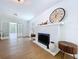Bright living room features brick fireplace, wood floors, and glass doors to the sunroom at 763 Siesta Dr, Sarasota, FL 34242