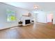 Spacious living room with brick fireplace, wood floors, lots of natural light, and white walls at 763 Siesta Dr, Sarasota, FL 34242