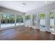 Sun room with wood floors and walls of windows overlooking the lush landscaping and exterior patio at 763 Siesta Dr, Sarasota, FL 34242