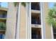 Exterior of condo building with palm trees, unit number, and balconies at 7803 Grand Estuary Trl # 205, Bradenton, FL 34212
