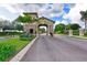 Elegant community entrance featuring stone pillars, lush landscaping, and manicured grounds under a sunny sky at 7803 Grand Estuary Trl # 205, Bradenton, FL 34212