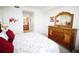 The main bedroom has a wooden dresser and a view of an ensuite bathroom at 7803 Grand Estuary Trl # 205, Bradenton, FL 34212