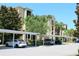 Covered parking in front of the condo building with beautiful landscaping and mature palm trees at 7803 Grand Estuary Trl # 205, Bradenton, FL 34212