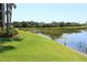 Beautiful view of a tranquil pond, featuring lush green grass and a heron by the water's edge at 7803 Grand Estuary Trl # 205, Bradenton, FL 34212