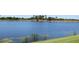 Scenic view of a serene pond bordered by lush greenery and palm trees, offering a tranquil atmosphere at 7803 Grand Estuary Trl # 205, Bradenton, FL 34212