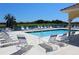 Relaxing pool area with lounge chairs overlooking a scenic water view and lush greenery at 7803 Grand Estuary Trl # 205, Bradenton, FL 34212