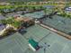 Aerial view of multiple tennis courts in a community with houses and a lake at 7803 Grand Estuary Trl # 205, Bradenton, FL 34212