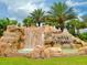 Scenic waterfall with lush greenery and palm trees, showcasing the community's natural beauty at 7803 Grand Estuary Trl # 205, Bradenton, FL 34212