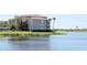 Beautiful view of the water with grassy landscaping and condo building at 7803 Grand Estuary Trl # 205, Bradenton, FL 34212