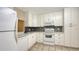 Bright kitchen featuring tile flooring, white cabinetry, and stainless steel appliances at 811 Oak Dr # 811, Bradenton, FL 34210