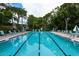 A long outdoor pool with swimming lanes surrounded by lounge chairs and greenery for recreation at 811 Oak Dr # 811, Bradenton, FL 34210