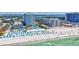 Aerial view of a luxury beachside resort featuring white sand, turquoise water, and numerous beach amenities at 845 Benjamin Franklin Dr # 106, Sarasota, FL 34236