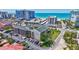 Aerial view of a condo building, showing a parking lot, surrounding landscaping, nearby beach, and other buildings at 845 Benjamin Franklin Dr # 106, Sarasota, FL 34236