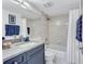 Bathroom featuring a navy vanity with granite countertop and shower over tub with safety bar at 845 Benjamin Franklin Dr # 106, Sarasota, FL 34236