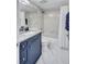 Bathroom featuring a navy vanity with granite countertop and shower over tub with grab bars at 845 Benjamin Franklin Dr # 106, Sarasota, FL 34236
