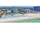 Beachfront view, highlighting the sparkling turquoise waters, sandy shore, pool and coastal buildings at 845 Benjamin Franklin Dr # 106, Sarasota, FL 34236
