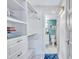 Walk-in closet with custom shelving and storage leading to an ensuite bathroom at 845 Benjamin Franklin Dr # 106, Sarasota, FL 34236