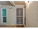 Front entry door featuring decorative storm door and tile flooring at 845 Benjamin Franklin Dr # 106, Sarasota, FL 34236
