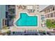 Aerial view of a swimming pool surrounded by lounge chairs and well-maintained landscaping at 845 Benjamin Franklin Dr # 106, Sarasota, FL 34236