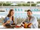 A couple enjoys a meal by the inviting poolside setting, creating a relaxed and social atmosphere at 845 Benjamin Franklin Dr # 106, Sarasota, FL 34236