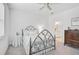 Bedroom with a decorative iron bed frame, neutral tones, dresser, and connected bathroom providing a comfortable atmosphere at 8553 Whispering St, Sarasota, FL 34240