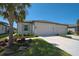 Charming home with a two-car garage, well-maintained lawn, and tropical landscaping at 8553 Whispering St, Sarasota, FL 34240