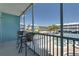 Screened in balcony with seating provides serene views of a swimming pool and tennis court at 901 Gulf S Dr # 3, Bradenton Beach, FL 34217