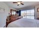 Bright bedroom featuring a ceiling fan, balcony access and a large dresser with decorative mirror at 901 Gulf S Dr # 3, Bradenton Beach, FL 34217