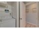 Clean laundry area featuring a washing machine, shelving, and a view into another room at 901 Gulf S Dr # 3, Bradenton Beach, FL 34217