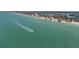 Wide aerial shot of a boat cruising along the coast with white sand beaches at 9265 Blind Pass Rd, Sarasota, FL 34242