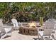 Cozy backyard fire pit, surrounded by Adirondack chairs, provides the perfect setting for outdoor gatherings at 9265 Blind Pass Rd, Sarasota, FL 34242