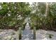 Private dock pathway with wood posts leads to the waterfront, creating a serene and inviting outdoor space at 9265 Blind Pass Rd, Sarasota, FL 34242