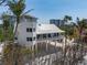 Unique beach home with a tower, wraparound porch, and modern design blends elegance with coastal living at 9265 Blind Pass Rd, Sarasota, FL 34242