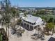 Stunning elevated home features a modern design, metal roof, and wraparound porch, nestled amid lush landscaping at 9265 Blind Pass Rd, Sarasota, FL 34242