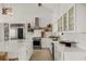 Modern white kitchen with stainless steel appliances, spacious countertops, and ample cabinet storage at 9265 Blind Pass Rd, Sarasota, FL 34242