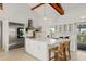 Bright kitchen features white cabinets, stainless steel appliances, island with seating, and vaulted ceilings at 9265 Blind Pass Rd, Sarasota, FL 34242