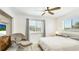 Bright bedroom featuring a large window, ceiling fan and cozy chair at 10008 Spoonbill E Rd, Bradenton, FL 34209