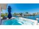 Waterfront patio with a luxurious hot tub, offering stunning views of the canal and boat dock at 10008 Spoonbill E Rd, Bradenton, FL 34209