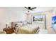 Bedroom with waterfront views from the window with a ceiling fan and a TV at 10008 Spoonbill E Rd, Bradenton, FL 34209