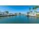 Scenic waterfront view of the canal lined with docks, homes, and lush palm trees under a clear blue sky at 10008 Spoonbill E Rd, Bradenton, FL 34209
