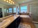 Elegant bathroom showcasing a double vanity, soaking tub, and glass-enclosed shower for a spa-like experience at 10934 79Th E St, Parrish, FL 34219