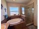 Luxurious bathroom featuring a soaking tub, glass-enclosed shower, and elegant fixtures for a spa-like experience at 10934 79Th E St, Parrish, FL 34219