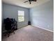 Comfortable bedroom featuring a ceiling fan, neutral carpet, and a window providing natural light at 10934 79Th E St, Parrish, FL 34219